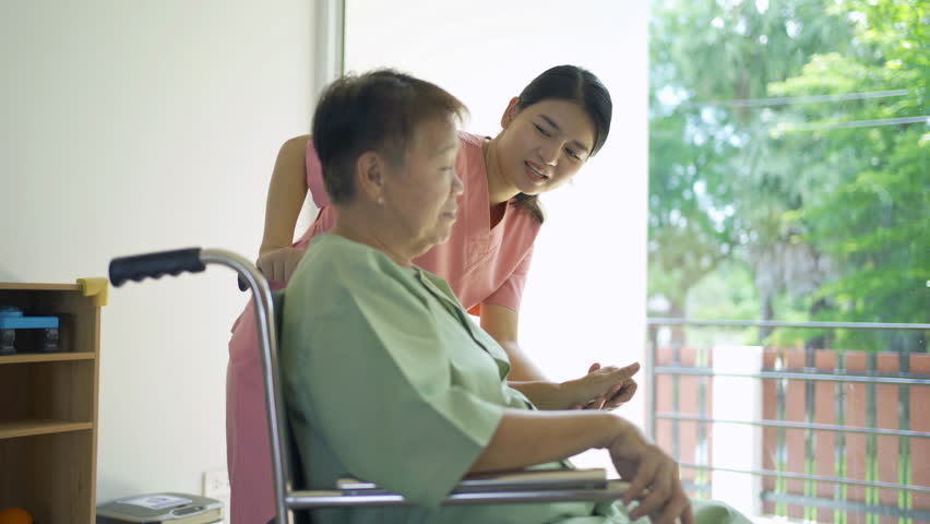Woman nurse hands check up body of sick old senior elderly patient sitting on wheelchair in hospital in medical and healthcare treatment. Asian Thai people lifestyle. Family encourage. | Shutterstock HD Video #1098959925