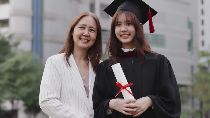 Happy Asian mother and graduated daughter take a picture in campus university together. Royalty-Free Stock Footage #1098961029
