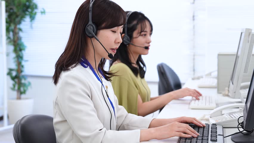 A female staff member dealing with a customer at a call center Royalty-Free Stock Footage #1098961943