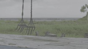old swing on the seashore with cloudy sky, flat video