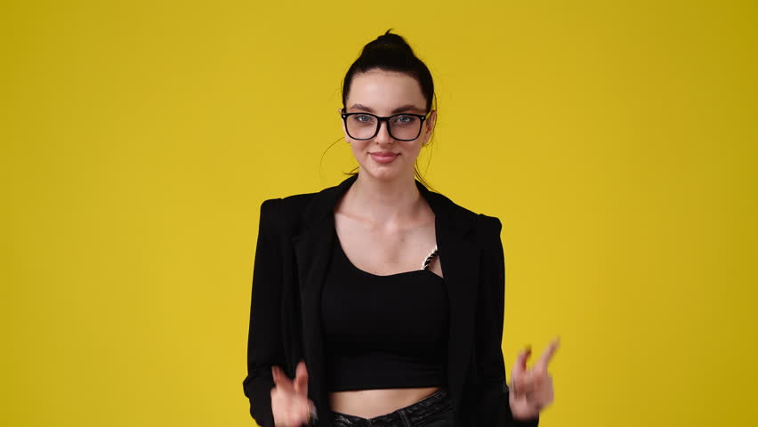 4k slow motion video of one girl pointing at camera and showing thumb up over yellow background. | Shutterstock HD Video #1098964419