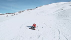 4K drone footage of snowboarder on a snowy mountain in the Alps. High quality video of man snowboarding at a ski resort.
