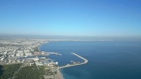 View from a height of 300 meters on the coastline of Antalya in Turkey and the sea cargo port on a sunny day. High quality 4k footage