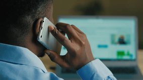 Back unknown african man male businessman employee web designer client develop internet website scrolling screen interface digital page talk mobile phone discuss business project over shoulder view - Powered by Shutterstock - Get 15% off with code: PIKWIZARD15