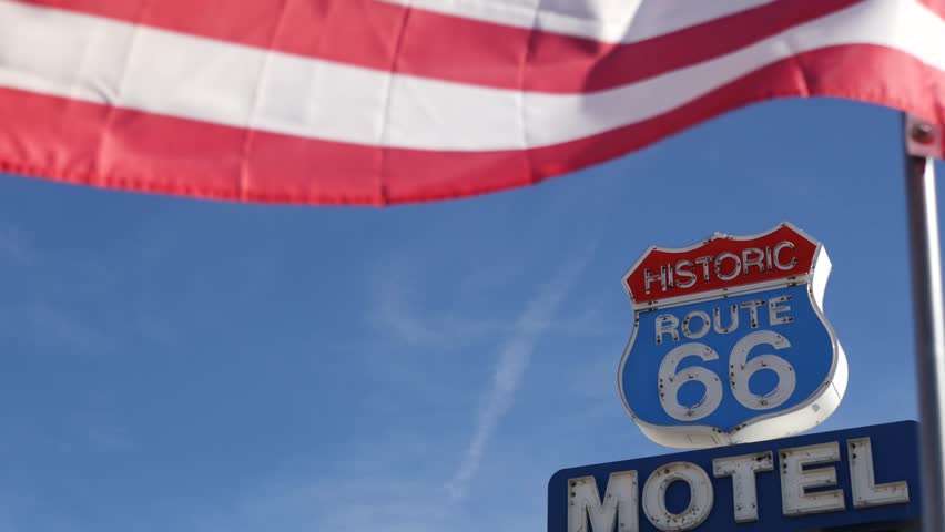Motel retro sign on historic route 66 famous travel destination, vintage symbol of road trip in USA. Iconic lodging signboard in Arizona desert. Old-fashioned neon signage. National state flag waving.