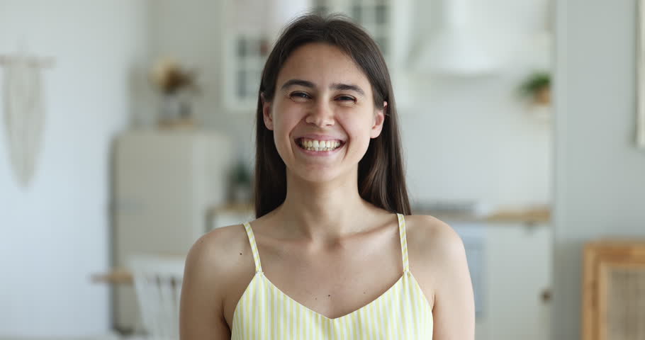 Head shot pretty young woman pose standing alone in domestic kitchen. Portrait of beautiful millennial female in casual clothes smile staring at camera looks happy spend weekend at own or rented flat | Shutterstock HD Video #1098976613