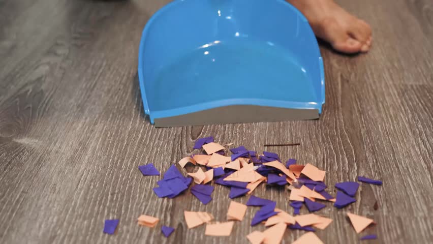 African-American man cleaning and sweeping confetti off the floor after a children's party, close up | Shutterstock HD Video #1098976951