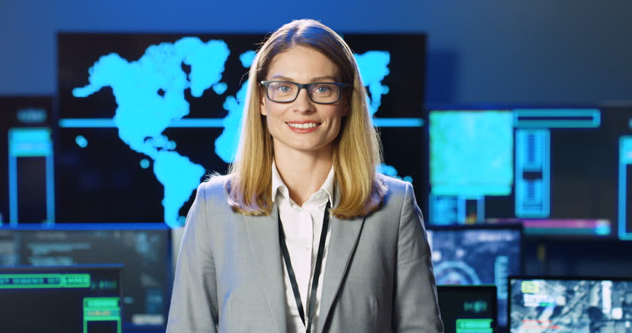 Portrait of beautiful Caucasian woman in glasses looking at camera, smiling and standing in military database geolocation center. Surveillance office concept. Female at secret data governmental agency | Shutterstock HD Video #1098981905