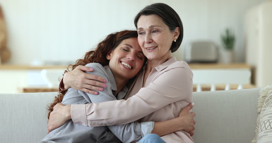 Mature mother hugging tightly her millennial daughter laughing enjoy time together. Two younger and older beautiful relatives women cuddling after long separation express love feel happy. Family ties Royalty-Free Stock Footage #1098982697