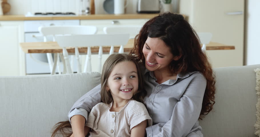 Adoption, happy motherhood, childcare, young caring mother and little daughter portrait. Beautiful Hispanic woman cuddling cute preschooler girl, smile staring at camera, feeling unconditional love | Shutterstock HD Video #1098982713
