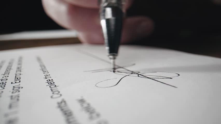 Close-up of a document or contract and cropped view of a hand putting signature, signing document. Business agreement. Successful deal.