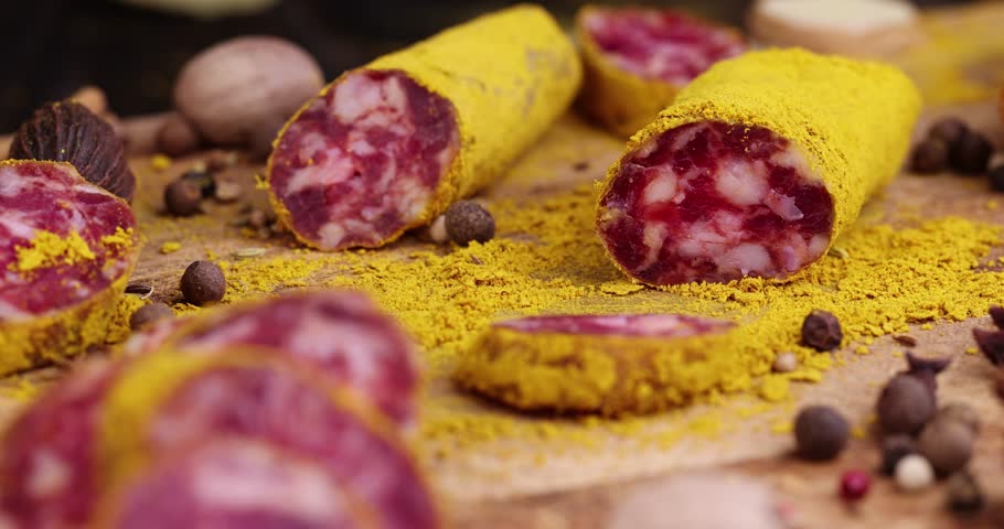 Slicing pork sausage marinated in a large amount of turmeric , dried meat with spices close - up
