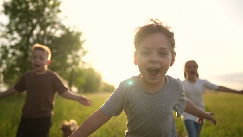children in the park. a group of children in a team hands to the sides run screaming play pilot dream of becoming a pilot. happy family kid dream sun concept. a team children run through the park Royalty-Free Stock Footage #1098993075