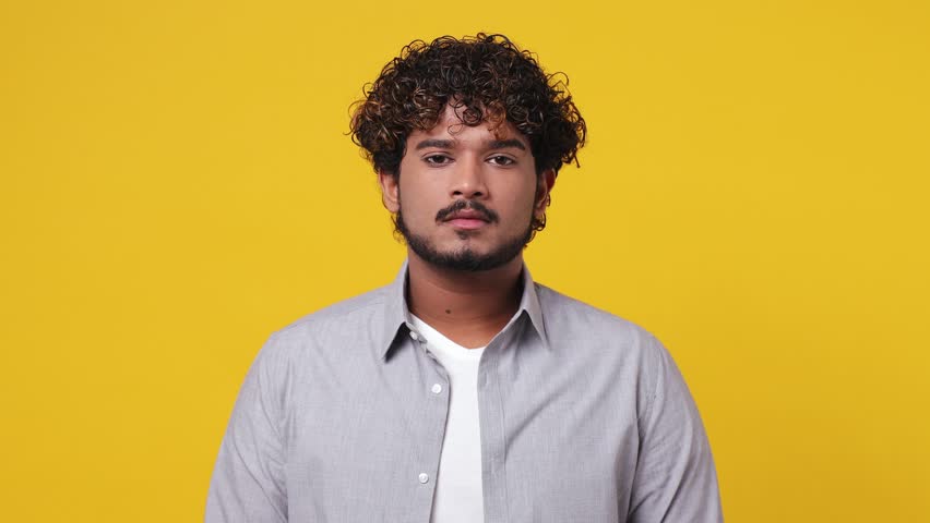 Displeased irritated sad angry young Indian man 20s wearing casual grey shirt closed eyes cover ears do not want to listen scream isolated on plain yellow background studio. People lifestyle concept Royalty-Free Stock Footage #1098995399