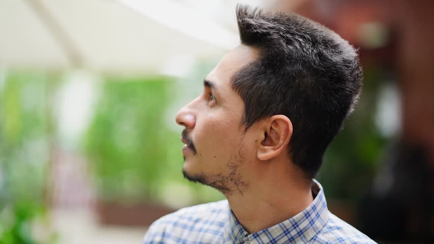 Young man asian looking at success, he turned and smiled happily at the camera.Close up face of young young cool trendy man in plaid shirt standing outside in cafe. | Shutterstock HD Video #1098997273
