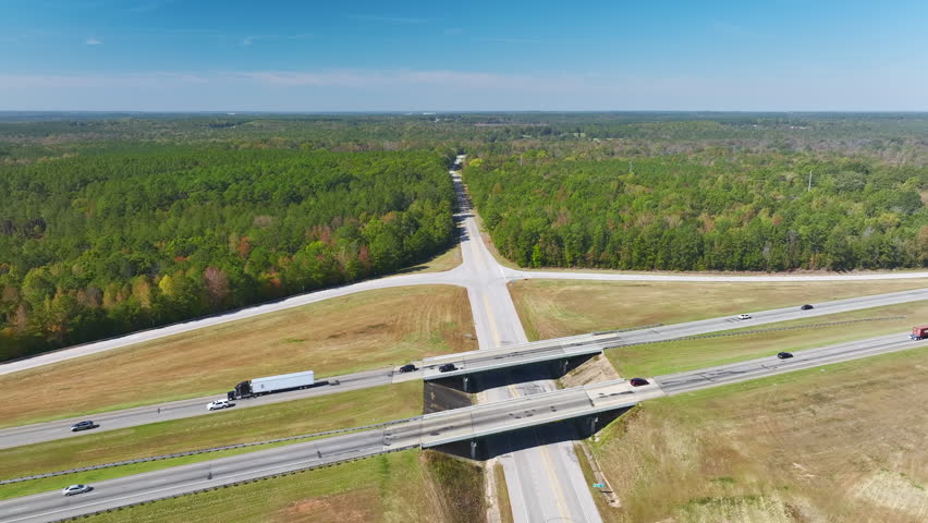 Elevated view of freeway exit junction over road lanes with fast moving traffic cars and trucks. Interstate transportation infrastructure in USA