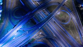 Highway aerial view night time lapse. Speed ramps, expressway lanes roads and bridges. Aerial view of multilevel road junction with high speed moving cars. Road highway intersection interchange. - Powered by Shutterstock - Get 15% off with code: PIKWIZARD15