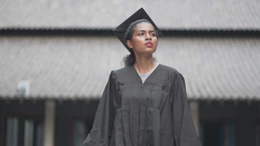 African people students man and woman with black graduation gowns hold the diploma and stand together. With the feeling of happy and graceful.