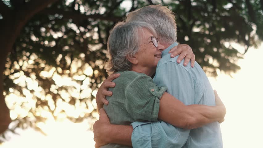 Head shot close up portrait happy grey haired middle aged woman snuggling to smiling older husband, enjoying tender moment at park. Bonding loving old family couple embracing, feeling happiness.
 Royalty-Free Stock Footage #1099031303