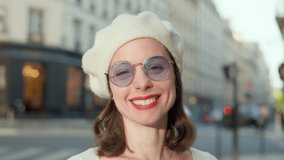 Smiling young woman in beret looking at camera outdoors