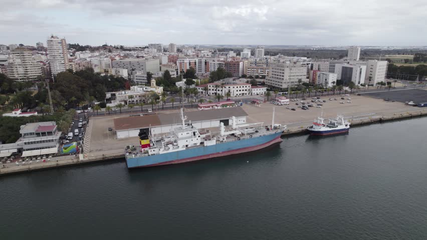 Aerial tracking docked Work ship in industrial port of Huelva, Spain