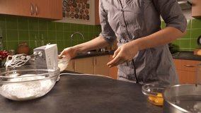 A close-up shot of a young woman adding yolk into a honey butter mixture and using an electric mixer to mix them together.