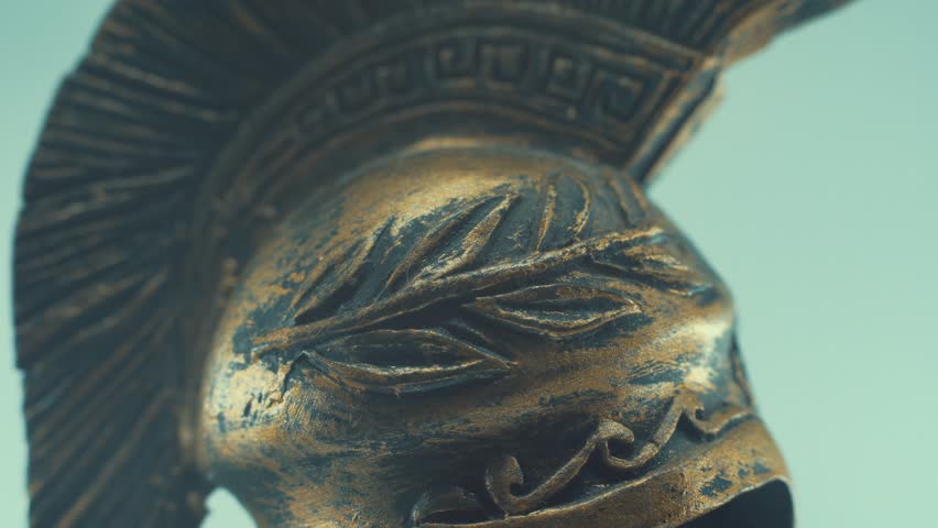 A rotating close up macro shot of a spartan warrior metal bronze ancient greek helmet, with shapes and forms on top, studio lighting, slow motion, 4K video Royalty-Free Stock Footage #1099039279