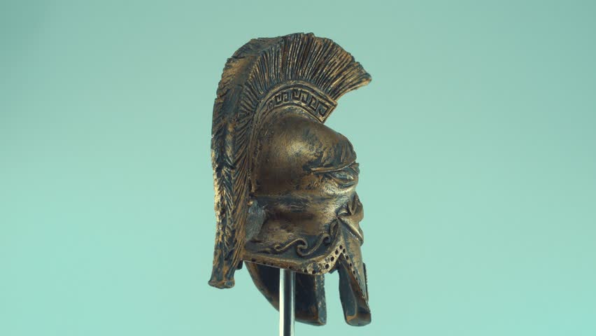 A rotating close up shot of a spartan ancient greek warrior metal bronze helmet, with shapes and forms, studio lighting, slow motion, 4K video Royalty-Free Stock Footage #1099039679