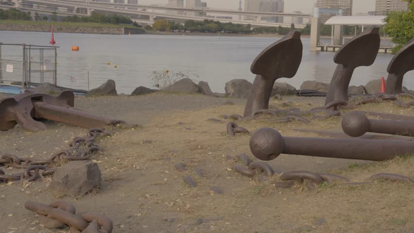 This panning video shows a landscape with huge old ship anchors embedded in the shoreline. 