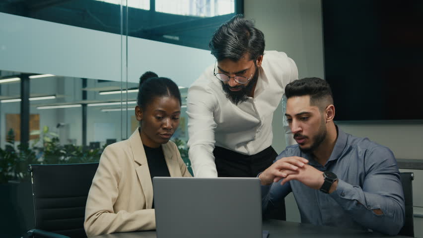 Arabian Indian leader business coach mentor businessman company CEO man corporate trainer boss teaching diverse interns managers African American woman and ethnic guy use laptop computer service app | Shutterstock HD Video #1099041909