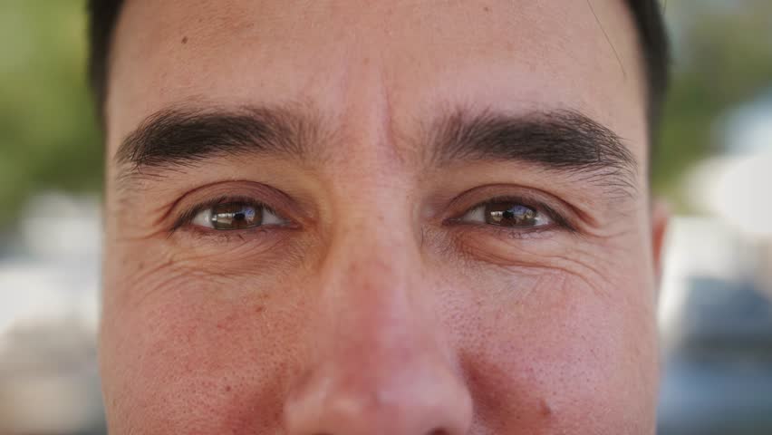 Close up of face. Young man looks at the camera, blinks, and smiles. | Shutterstock HD Video #1099046737