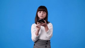 4k slow motion video of one girl talking over the phone on blue background.
