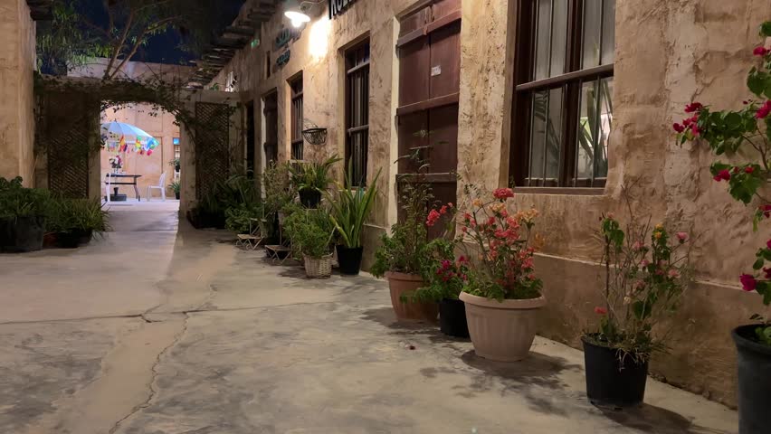 A super beautiful girl walking in old city down town wakrah souq Doha Qatar at night safe and cozy place with flowers and antique architectural design during FIFA world cup football tournament