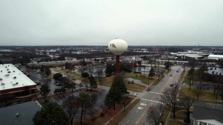 aerial above vernon hills with water tower in center on rush hour at the sunset 4k video, visible a bit the orchard vernon hills evagelical church