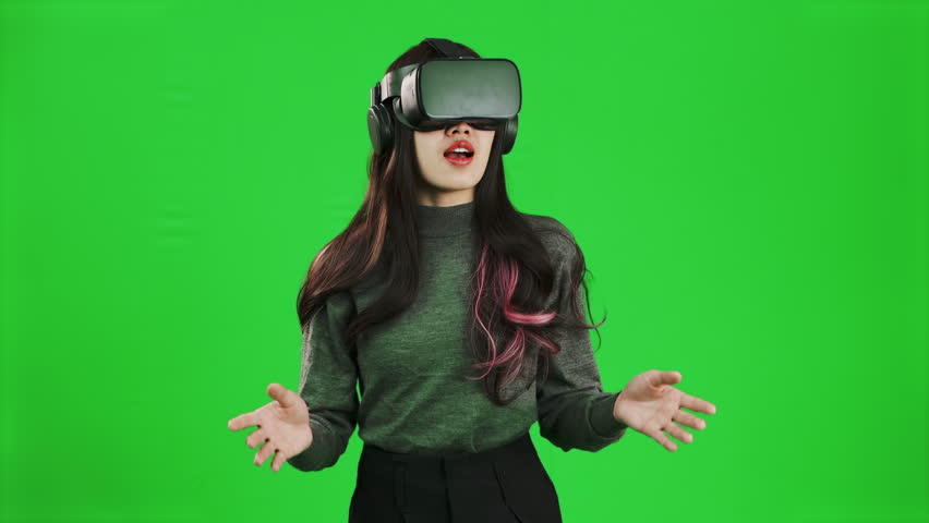 Asian woman long hairstyle wearing vr goggles headset watching, playing, touching on green screen backgroun. 4K footage Metaverse concept. Royalty-Free Stock Footage #1099059869