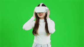 Metaverse woman wearing vr headset posing touching, watching, playing on green screen background in video 4K.