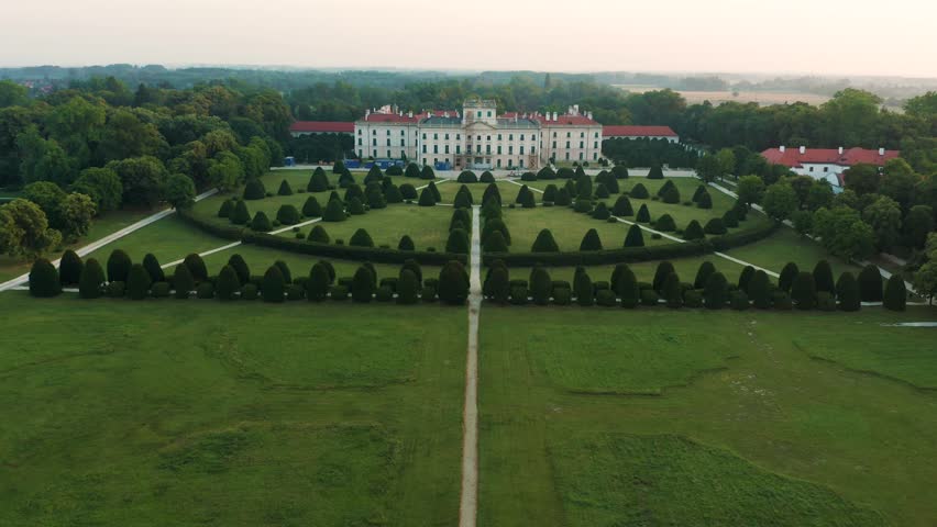 Fertod, Hungary - 4K Aerial view of Eszterhazy Palace near Sopron. Flying over Eszterhazy castle and garden on a bright summer morning at sunrise