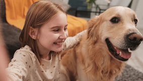 Preteen girl with golden retriever dog recording vlog content for social media. Pretty teen child with doggy pet making blog video