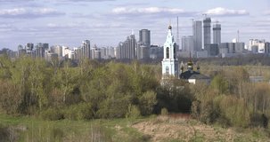 4K quality morning video scenic view of beautiful light blue church overlooking green park, distant city and hills in Krylatskoye area in Moscow