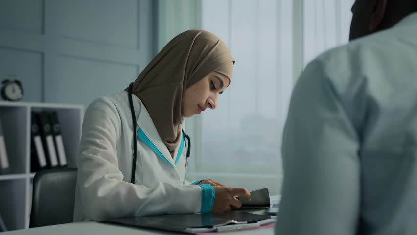 Muslim arabian woman young female doctor therapist write medical prescription recipe for sick patient writing notes filling checklist illness symptoms show health insurance to male client at clinic Royalty-Free Stock Footage #1099081333