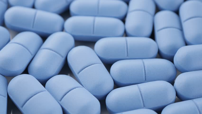 Blue pills close up, rotation. Pharmaceutical Industry. The medicine concept