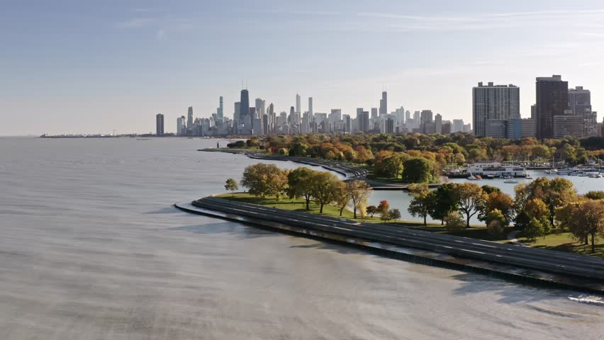 Aerial drone view of downtown Chicago skyline from over Lake Michigan near Belmont harbor on a sunny blue sky day in autumn season.