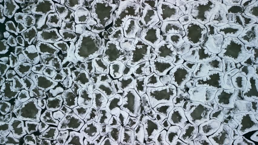 Aerial top down 4k video of interlocking ice chunks swaying with the current on Lake Ontario