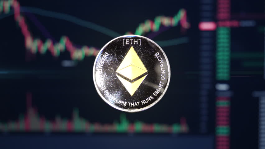 Ethereum ETH crypto currency coin hovering in front of trading charts with light energy passing through | Shutterstock HD Video #1099090531