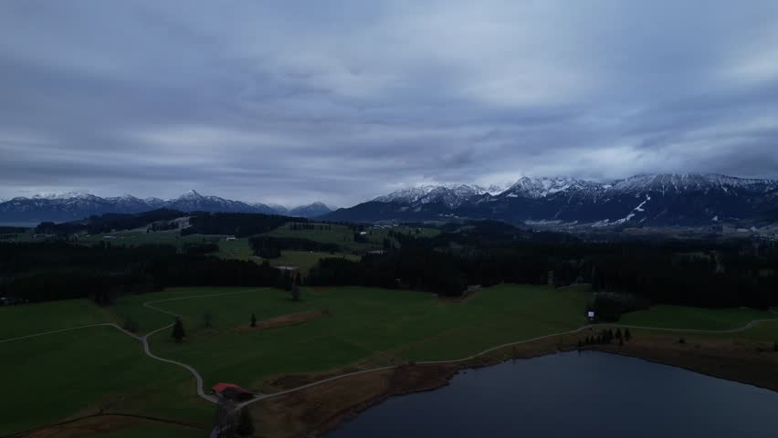 DRONE AERIAL FOOTAGE: Winter view from the Allgau Alps mountain range in the Northern Limestone Alps and alpine lake Attlesee, located near Nesselwang town, Bavaria, Germany.