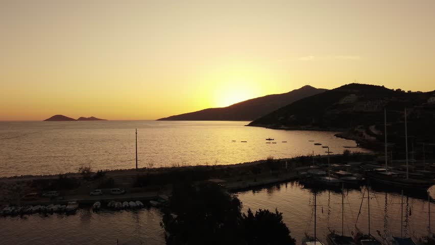 Aerial view of Bali beach island and sliver of sand on Sunset beach in the evening, sunset sea view with mountains, drone aerial.