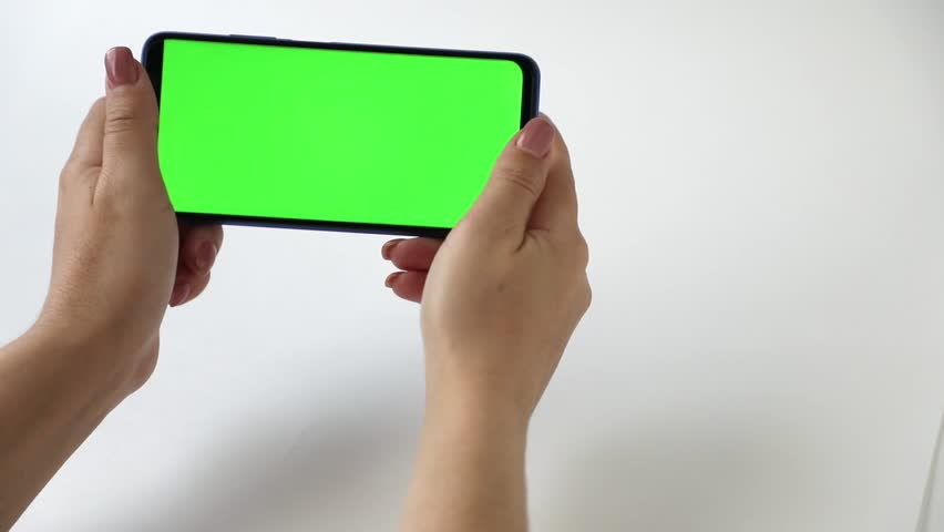 In the hands of a phone with a green screen on a light background	 | Shutterstock HD Video #1099094567