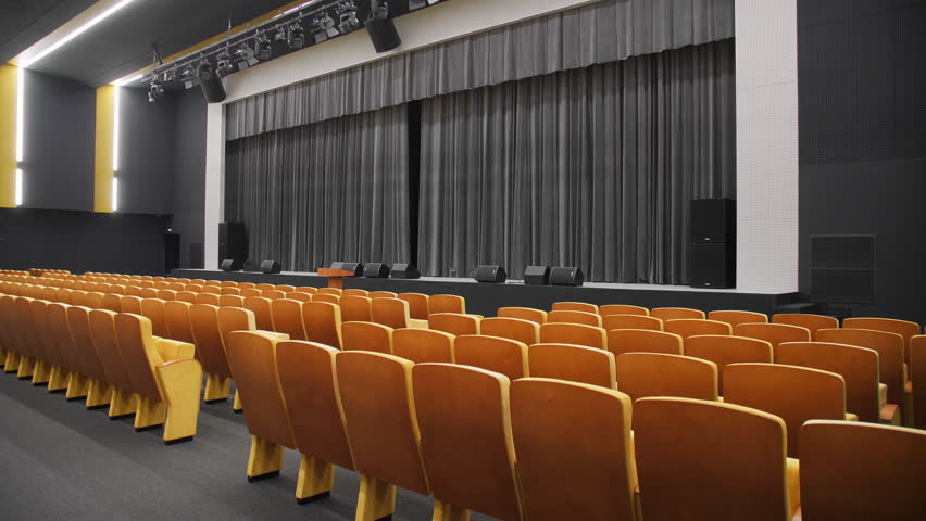 Chair rows and stage with black curtain in empty hall of theatre. Enclosure with furniture and space for performance