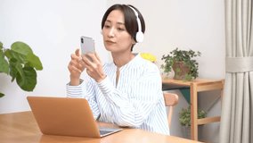 Japanese woman holding a mobile phone and listening to music