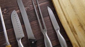 Video of various knifes and sharpening tools placed on table in a row, honing rod and sanding whetstone for sharpening steel tools and knifes for chefs and cooks, close up video clip, 4k footage